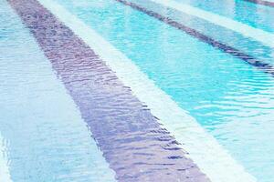A man in a blue suit is standing in a pool photo