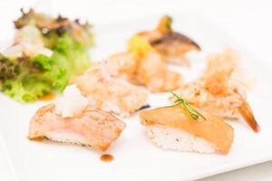 A plate with sushi and salad on it photo