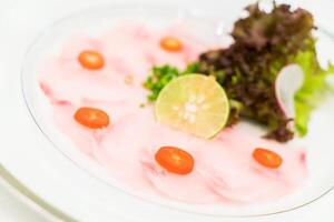 A plate with pink fish and vegetables on it photo
