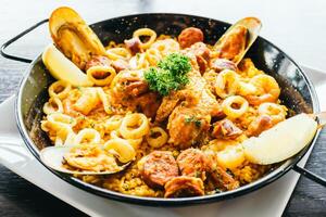 A pan with seafood and rice on top photo