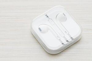 An apple earbud in a white box on a wooden table photo