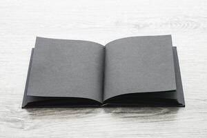 An open black book on a wooden table photo