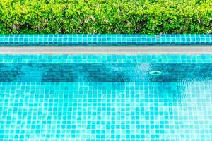 Top view of swimming pool with green grass and blue tiles photo
