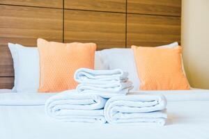 Towels on a bed with pillows and orange pillows photo