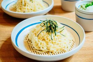 Two bowls of noodles sit on a table photo
