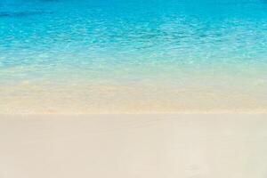 A white sand beach with clear water and a blue sky photo