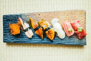 A wooden tray with various types of sushi photo