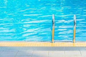A pool with a ladder and a blue sky photo