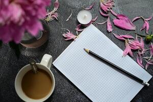 top view office desk desk. A workspace with an empty notepad, stationery, pencil and coffee cups on a dark background. photo