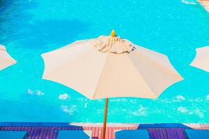 A pool with umbrellas and chairs photo