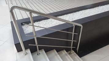 Metallic railing along the staircase. Railing protection from falling down on the staircase. Elderly and disabled people care. photo