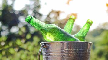 Green beer bottle rest in a bucket of ice, symbolizing refreshment and relaxation, perfect for unwinding during social gatherings or celebrating special moments. photo