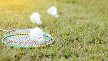 A badminton racket and shuttlecock resting on a grassy field, symbolizing the joy of outdoor sports, healthy living, and the importance of recreational activities to build fitness and bonds. photo