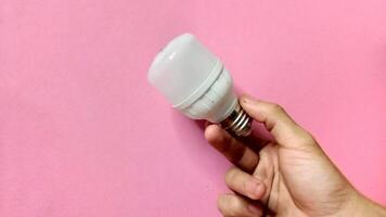 Energy efficient LED light bulb in hand. Concept of sustainability, innovation, and bright ideas. photo