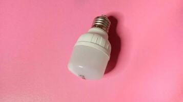 Energy efficient LED light bulb on a pink background. Concept of innovation, technology, and sustainability. photo