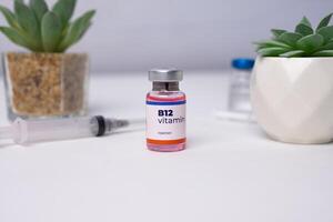 a liquid vitamin b12 with a syringe on the clinic table. health and medical concepts photo