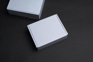 Two white boxes lying on a black surface photo