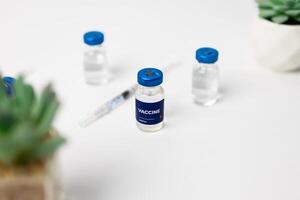 top view of 3 vaccines and a syringe on the table. health and medical concept photo