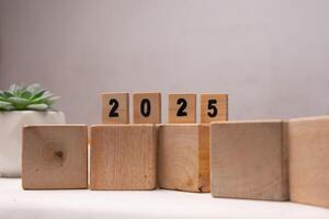 wooden scrabble labeled with numbers 2025 on the wooden cube block, new year concept photo