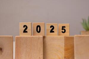 wooden scrabble labeled with numbers 2025 on the wooden cube block, new year concept photo