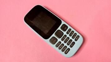 Basic Cell Phone on Pink Background, Minimalist Technology Image photo