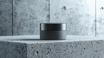 A small jar of cream sits on a grey stone slab. The scene is simple and minimalistic, with the focus on the jar and the stone slab photo