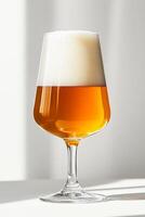 A glass of beer is sitting on a table. The glass is half full and the beer is foamy. Concept of relaxation and enjoyment, as the beer is a popular beverage for unwinding and socializing photo