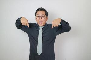 Asian office man wearing black shirt doing pointing in down gesture, isolated white office man concept photo