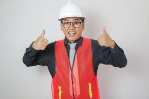 asiático construcción trabajador retrato pulgar arriba en blanco antecedentes foto