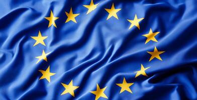 A blue and yellow flag with stars in the center. The flag is from Europe. The flag is waving in the wind photo
