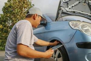 Close up auto mechanic man checking car tire . Car service. Hands replace tires on wheels. Tire installation concept. photo
