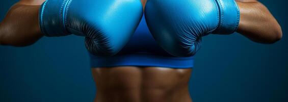 A woman wearing a blue boxing glove is posing for a picture. Concept of strength and athleticism photo