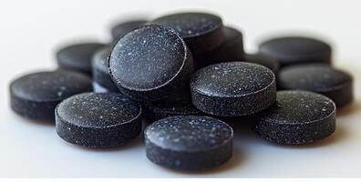 A pile of black pills with white background. Concept of seriousness and importance, as if the pills are a crucial part of someone's life photo