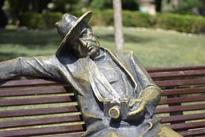 Relaxed Bronze Statue on Bench photo