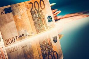 Close-up of a 200 Euro Bill Reflecting on a Smooth Surface in a Dimly Lit Setting photo