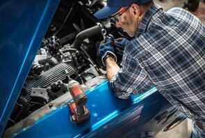 Skilled Mechanic Repairs Engine Inside Workshop During Afternoon photo
