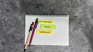 Concept of ESG - Environment Social Governance write on sticky notes isolated on Wooden Table. photo
