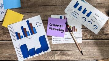 Concept of Customer Onboarding write on sticky notes isolated on Wooden Table. photo