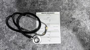 Concept of Health Insurance write on document isolated on Wooden Table. photo