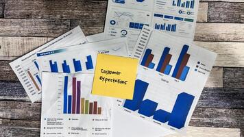 Concept of Customer Expectations write on sticky notes isolated on Wooden Table. photo