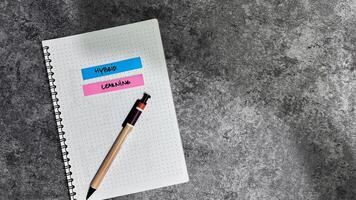Concept of Hybrid Learning write on sticky notes isolated on Wooden Table. photo