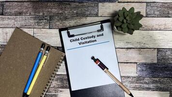 Concept of Child Custody and Visitation write on paperwork isolated on Wooden Table. photo
