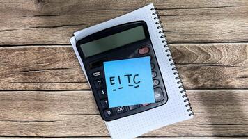 Concept of EITC write on sticky notes isolated on Wooden Table. photo