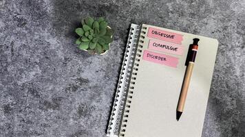 Concept of Obsessive Compulsive write on sticky notes isolated on Wooden Table. photo