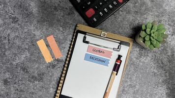 Concept of Global Recession write on sticky notes isolated on Wooden Table. photo