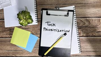 Concept of Task Prioritization write on paperwork isolated on Wooden Table. photo