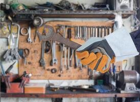 Hand in glove holding spanner photo