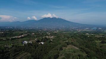 Aerial footage showcasing the majestic view of Mount Gede Pangrango, captured by a drone, highlighting its lush greenery and towering peaks in a serene natural setting video