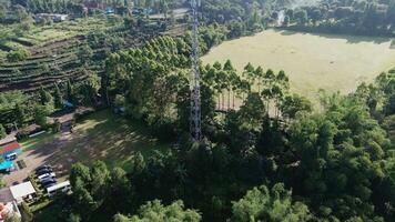 Drone view of a hill with a vast field and a telecommunications tower in the distance. Perfect for landscapes, technology, or rural projects highlighting nature and infrastructure. video