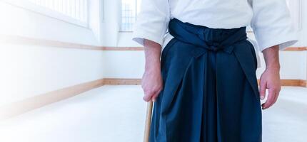 Man practicing aikido in a dojo background. photo